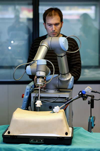 Un investigador manipulando uno de los brazos del robot