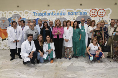 Profesionales, pacientes y autoridades posan tras la inauguración de la muestra 'Trasplantando Sonrisas'