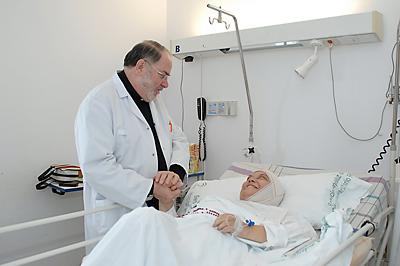 El capellán Rafael María consuela a una paciente.